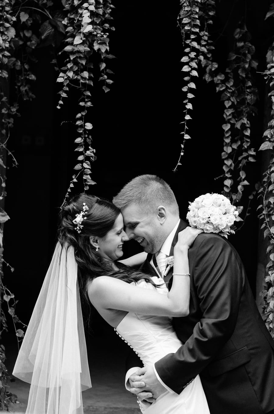 Kriszti and Szabolcs on their wedding day, foreheads touching, laughing